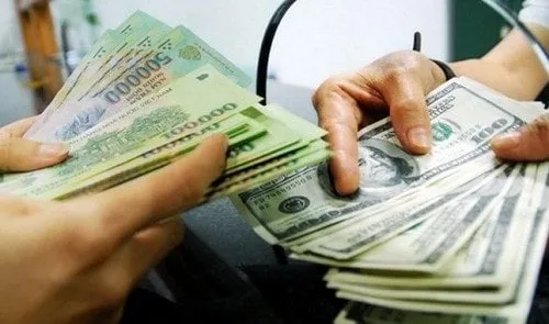 Two pairs of hands exchanging a stack of banknotes for a stack of US hundred dollar bills across a counter